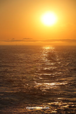 PÔR DO SOL NO MAR. OCASO. BARCO. PAISAGENS. GALIZA. ESPANHA