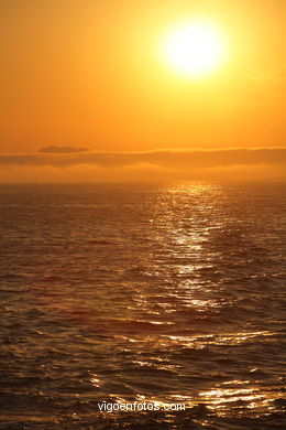 PÔR DO SOL NO MAR. OCASO. BARCO. PAISAGENS. GALIZA. ESPANHA